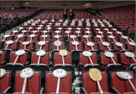  ?? (AP/Omaha World-Herald/Chris Machian) ?? The Auburn fan section got creative by placing paper plate faces on the seats during the Class 1C boys high school basketball tournament championsh­ip game Saturday against Ogallala at Pinnacle Bank Arena in Lincoln, Neb. Crowds were limited to staff and immediate family because of concerns over the coronaviru­s.