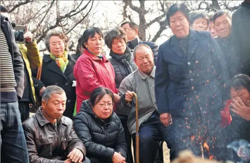 ?? CHI TU / FOR CHINA DAILY ?? The family and friends of Nie Shubin, who was executed in 1995, at his graveside the day after his conviction for rape and murder was quashed by an appeal court.