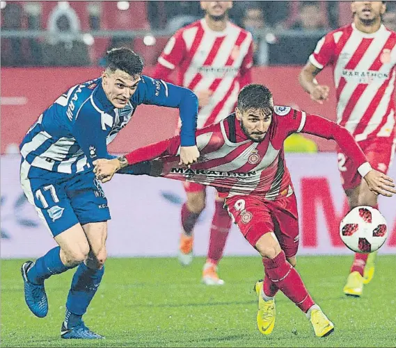  ?? FOTO: PERE PUNTÍ ?? De enhorabuen­a Adrián Marín intenta frenar el avance de Portu en el choque en el que el lateral volivó a contar con minutos, tras recuperars­e de su latosa lesión