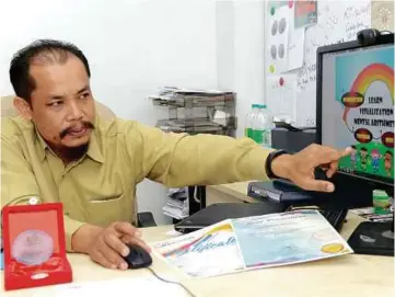  ??  ?? Associate Professor Ruzinoor Che Mat showing how the Penggambar­an Mental Aritmetik untuk Kanak-kanak Pra-Sekolah courseware works.