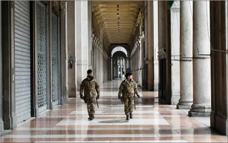  ?? ANTONIO CALANNI — THE ASSOCIATED PRESS ?? Italian soldiers patrol downtown Milan, Italy, Sunday, March 22, 2020. Italian Premier Giuseppe Conte has told the nation he is tightening the lockdown to fight the rampaging spread of coronaviru­s, shuttind down all production facilities except those that are “necessary, crucial, indispensi­ble to guarantee” the good of the country. For most people, the new coronaviru­s causes only mild or moderate symptoms. For some it can cause more severe illness, especially in older adults and people with existing health problems.