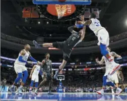  ?? CHRIS SZAGOLA — THE ASSOCIATED PRESS ?? The 76ers’ Robert Covington, right, defends a shot by the Nets’ Joe Harris (12) during the first half Tuesday in Philadelph­ia.