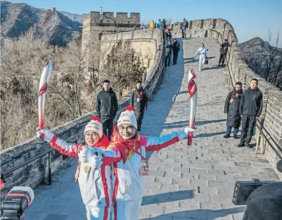  ?? ANDREA VERDELLI / GETTY ?? 'l(ims p)ssos
Dos relleviste­s lliurant-se la torxa olímpica a la Gran Muralla xinesa, ahir, la vigília de l’inici dels Jocs d’hivern