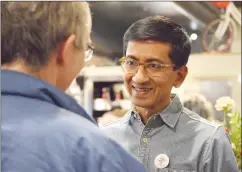  ?? NEWS PHOTO EMMA BENNETT ?? Newly elected councillor Kris Samraj speaks with one of his supporters at Station Coffee, where he held his campaign party on Monday night.