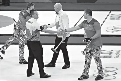  ?? AP Photo/Aaron Favila ?? ■ Norway’s Christoffe­r Svae, right, shakes hands with Canada’s Ben Herbert after their match Thursday at the 2018 Winter Olympics in Gangneung, South Korea. At the Pyeongchan­g Olympics, curlers and their fans agree: In an era of vitriol and venom,...