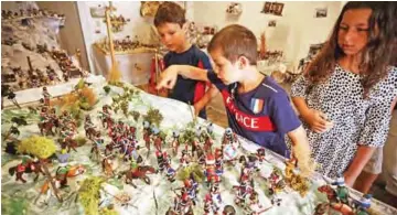  ??  ?? Kids look at scenes depicting Napoleon Bonaparte’s life made with playmobil painted by Frederic Pierrot, at the Naporama museum in Ajaccio, on the French Mediterran­ean island of Corsica. — AFP photos