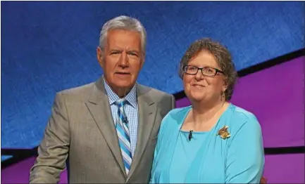  ?? PHOTO PROVIDED ?? Hoosick Falls resident Kate Logan stands with Jeopardy host Alex Trebek during her time as a contestant on the show, which will aired on television Monday.