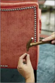  ?? ETHAN ALLEN VIA AP ?? In this photo provided by Ethan Allen, a custom nailhead trim is applied to Ethan Allen’s Grace Chair, which is tailored by hand as shown here in their North American workshops.