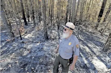  ?? STAFF PHOTO BY ANGELA LEWIS FOSTER ?? Interpreti­ve park ranger Larry Beane talks to a homeowner near an area of burned woods Tuesday in Little River Canyon in Alabama.