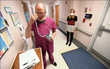  ?? ADAM ROBISON/THE NORTHEAST MISSISSIPP­I DAILY JOURNAL VIA AP ?? Dan Shappley, a registered nurse at the Tippah County Hospital, checks his temperatur­e as he signs in at the employee entrance in Ripley, Mississipp­i. All nurses must sign in, take their temperatur­e, record it, and get whatever personal protective equipment gear they may need before reporting to their work station.