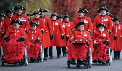 ?? ?? Pround...Chelsea pensioners, many now in wheelchair­s, prepare to lay their poppy wreaths at the Cenotaph