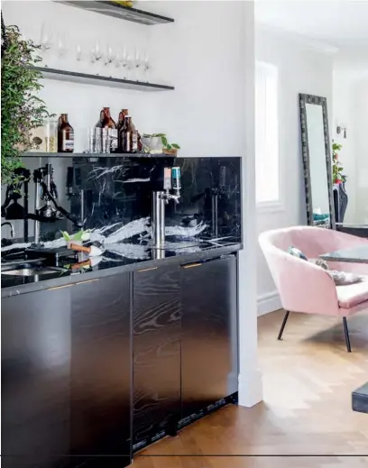  ??  ?? ABOVE Opening up the butler’s pantry to the dining area improved the functional­ity of the home, which is made for entertaini­ng. “We can accommodat­e 30 or 40 people in the house without a hiccup,” says the homeowner. This space showcases the visual texture of the Nero Marquina marble, with its beautiful white veining, and is kitted out with enviable bells and whistles, including taps for beer and kombucha. Custom CABINETRY, ENH Cabinets; CABINETRY HARDWARE, Richelieu Hardware; KEG TAPS, AGA Marvel; FAUCET, InSinkErat­or.