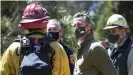  ??  ?? Governor Gavin Newsom talks with local and state fire officials while touring an area burned by last year’s Creek fire near Shaver Lake in Fresno county, California. Photograph: Craig Kohlruss/AP