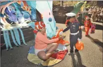  ?? Dan Watson /The Signal ?? Mary Heitmann, left, hands out candy from her “Finding Nemo” SUV to Caden Wrighster, 5, who dressed as a U.S. Marine on Friday in Valencia.