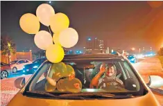  ??  ?? A woman and her friend celebrate the lifting of the ban by tying balloons to her car as she drove in Khobar City