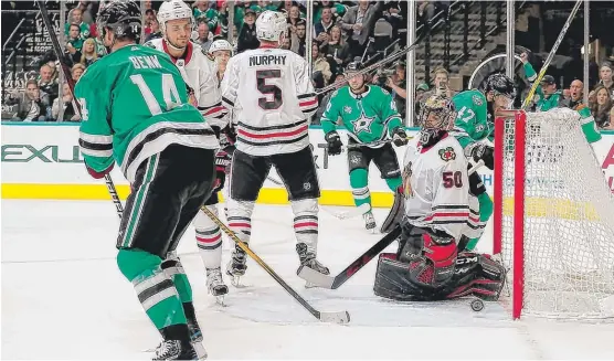  ?? | GETTY IMAGES ?? The Stars’ Jamie Benn scores against Hawks goalie Corey Crawford, who suffered his first regulation loss since Nov. 12.