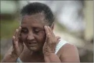  ?? CARLOS GIUSTI — THE ASSOCIATED PRESS ?? El Negro community resident Irma Torres Rodriguez tries to stay calm after loosing a portion of her roof to the fury of Hurricane Maria, in Puerto Rico, Sept. 21.