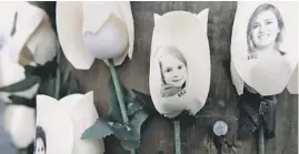  ?? SETH WENIG/AP ?? Photos of those killed in the shootings at Sandy Hook Elementary School are imprinted on fake roses Saturday at a memorial in Newtown, Conn.