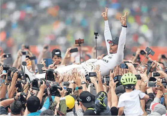  ?? Picture: PA. ?? Lewis Hamilton celebrates in customary fashion after delivering a masterclas­s at Silverston­e to win the British Grand Prix.