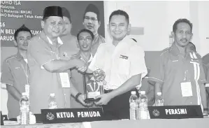  ??  ?? DISAKSIKAN oleh Norsalin dan yang lain Mohd. Faizal (kiri) menyampaik­an cendera kenangan kepada Mohd. Najib.