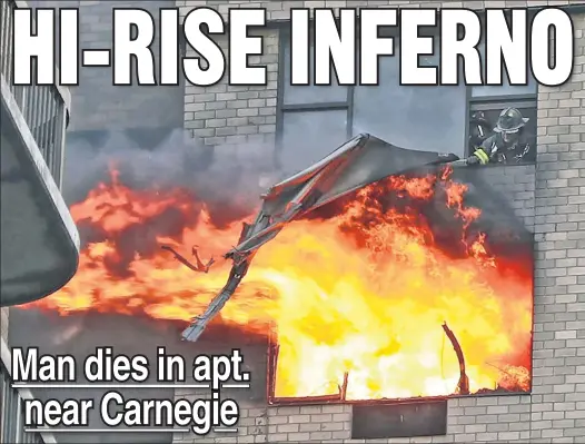  ??  ?? ‘WE WERE SLEEPING’: Flames shoot from a 35th-floor window at the Carnegie Mews on West 56th Street, where a 76-year-old designer died. Firefighte­rs were left exhausted after a slow elevator system forced them to climb stairs to battle the blaze.