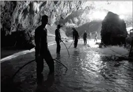  ?? ASSOCIATED PRESS ?? IN THIS PHOTO RELEASED by Royal Thai Navy on Saturday, Thai rescue teams arrange water pumping system at the entrance to a flooded cave complex where 12 boys and their soccer coach became trapped June 23 in Mae Sai, Chiang Rai province, northern...