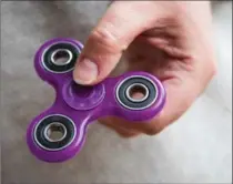 ?? DREW ANGERER, GETTY IMAGES ?? Fidget spinners have become the latest sensation and some schools have banned them because they’ve become a distractio­n.