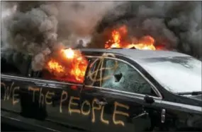  ?? THE ASSOCIATED PRESS ?? A parked limousine burns Friday during a demonstrat­ion after the inaugurati­on of President Donald Trump in Washington.