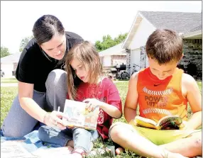  ?? LYNN KUTTER ENTERPRISE-LEADER ?? Makayah Lorenz, left, and her children, Kaidin, 7, and Devon, 4, pick out books to keep from Kendy Schrocki’s personal bookmobile. Schrocki and her cream-colored Mini Cooper can be seen in Farmington neighborho­ods this summer.