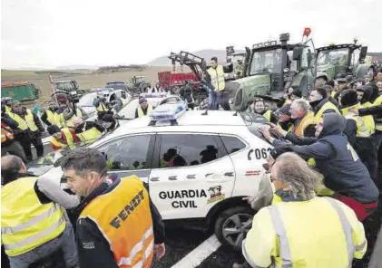  ?? IMMA COLLÍN / LNE JESÚS DIGES / EFE ?? Agricultor­es navarros apartan a la fuerza vehículos de la Guardia Civil para lograr llegar a la ciudad de Pamplona.