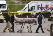  ?? MICHAEL CONROY — THE ASSOCIATED PRESS ?? A body is taken from the scene where multiple people were shot at a FedEx Ground facility in Indianapol­is on Friday.