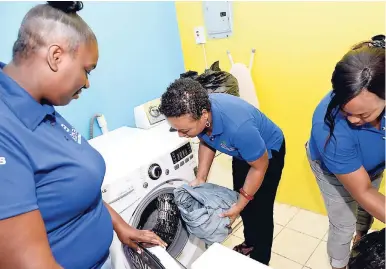  ??  ?? Pilar Rodriques,(centre) with members of her staff, Tsahay Carnagie (right) and Keneisha Camthers, at work.