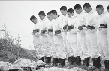  ?? Yuan Zheng
European Pressphoto Agency ?? RESCUERS observe a moment of silence for the victims whose bodies were recovered after a Chinese cruise ship capsized Monday on the Yangtze River in Hubei province. More than 410 people are still unaccounte­d for.
