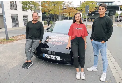  ?? RP-FOTO: STEFAN OSORIO-KÖNIG ?? Maik Richter (l.) gab Alisa Suchanek und Niko Kreutzberg die ersten Fahrstunde­n mit dem neuen Tesla Model 3.