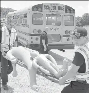  ?? Keith Bryant/The Weekly Vista ?? Fire Department personnel work to carry a pair of simulated patients to the treatment area. Capt. Leon Lieutard, background, surveys the scene.