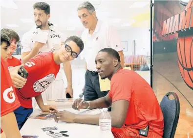  ?? AMY BETH BENNETT/STAFF PHOTOGRAPH­ER ?? Cyrus Scott, 12, leans in for a selfie with the Heat’s Bam Adebayo at the Heat’s youth camp at South Broward High School in Hollywood on Wednesday. Adebayo said he has devoted this summer to working on both his post game and his mid-range game.