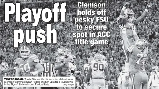  ?? Getty Images ?? TIGERS ROAR: Travis Etienne lifts his arms in celebratio­n as Clemson teammate Sean Pollard lifts him up after a touchdown in the Tigers’ 31-14 win over Florida State.