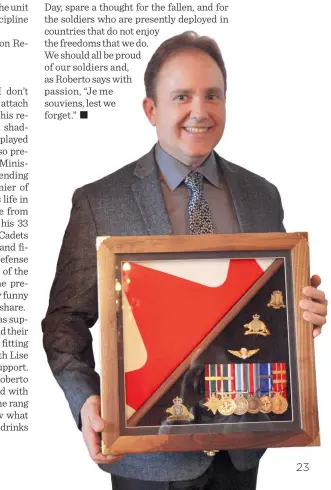  ??  ?? Below: Roberto holding the shadow box he was given containing his medals displayed beside the Canadian flag.