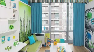  ??  ?? A condo room efficientl­y provides both a play area and a fun bedroom, with space-saving pieces from Resource Furniture. A wall bed becomes a funky city skyline behind a child’s sofa that stores toys, a shelving unit includes a fold-down desk, and a...