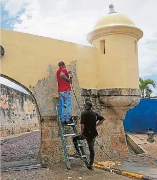  ?? EFE ?? Un obrero despinta el fuerte de San Sebastián, que fue vandalizad­o pese a ser un bien patrimonia­l.