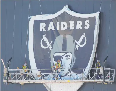  ?? Erik Verduzco Las Vegas Review-journal @Erik_verduzco ?? The Raiders’ emblem is hoisted into place Wednesday at the team’s headquarte­rs and practice facility in Henderson.