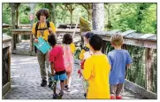  ?? (Courtesy of the Little Rock Zoo) ?? A counselor guides young
campers at the Little Rock Zoo’s Zoofari Camp in 2019. In-person summer camps are back with a vengeance in what appear to be the waning days of covid-19.