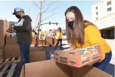  ?? STAFF PHOTO BY MATT HAMILTON ?? Stephani Womack places a box of noodles in a box during the Gratefull event in Burr Park in downtown Dalton on Monday.