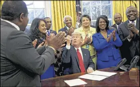  ?? AUDE GUERRUCCI-POOL/ GETTY IMAGES ?? President Donald Trump hands out pens after signing an executive order to support black colleges and universiti­es Tuesday at the White House.