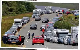  ??  ?? Post-bridge life: Visitors spill over onto yellow lines near the Old Man of Storr. Left, the 840-yard ribbon of concrete joining Skye to the mainland