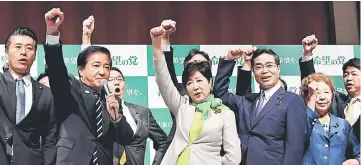  ??  ?? Koike (centre) poses with her party members during an inaugurati­on press conference on her new political party, ‘Party of Hope’, in Tokyo.— AFP photo