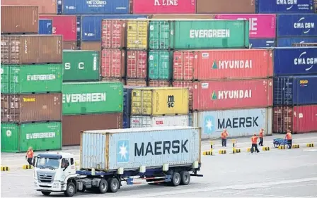  ?? STRINGER/REUTERS ?? A truck transports a container at a port in Qingdao, Shandong province, China, earlier this year.