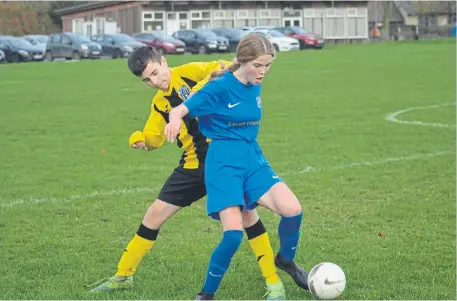  ?? ?? Heslerton under-14s (blue kit) hold off a Scalby Under-14s player in the Scarboroug­h & District Minor League clash PHOTO BY CHERIE ALLARDICE