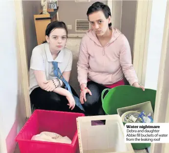  ??  ?? Water nightmare Debra and daughter Abbie fill buckets of water from the leaking roof