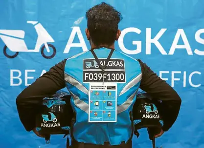  ?? — GRIG C. MONTEGRAND­E ?? Recy Lopez wears the special reflectori­zed vest for Angkas riders. Angkas puts a premium on safety, not just of the driver but the passenger as well.
